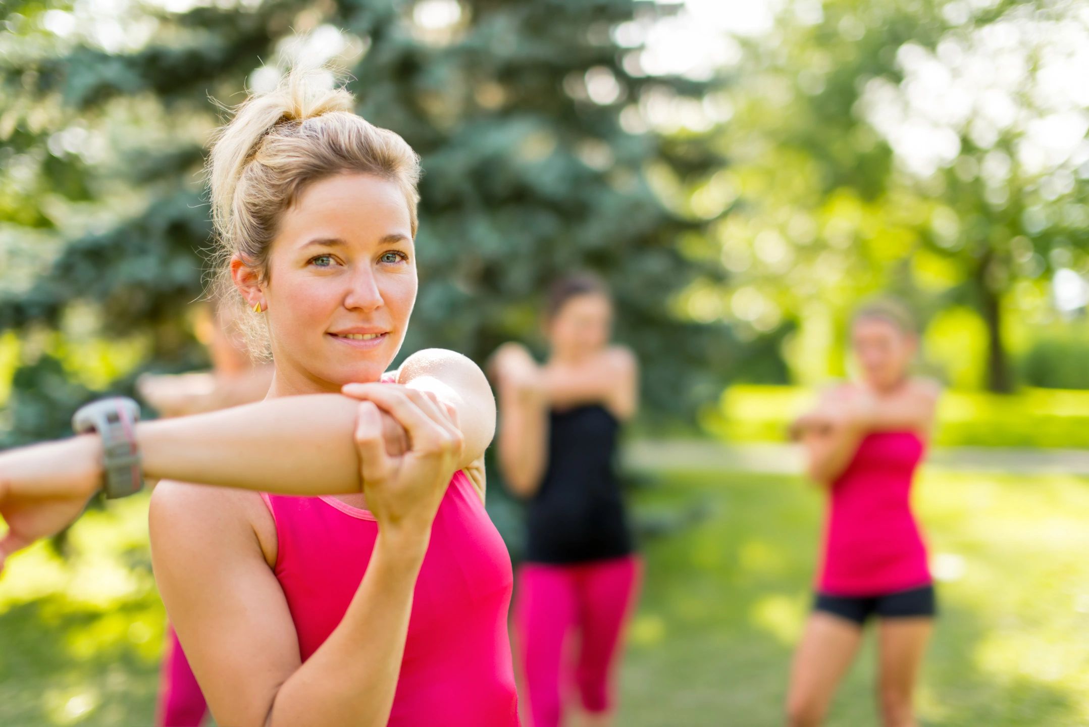 A woman in pink shirt holding a stick.