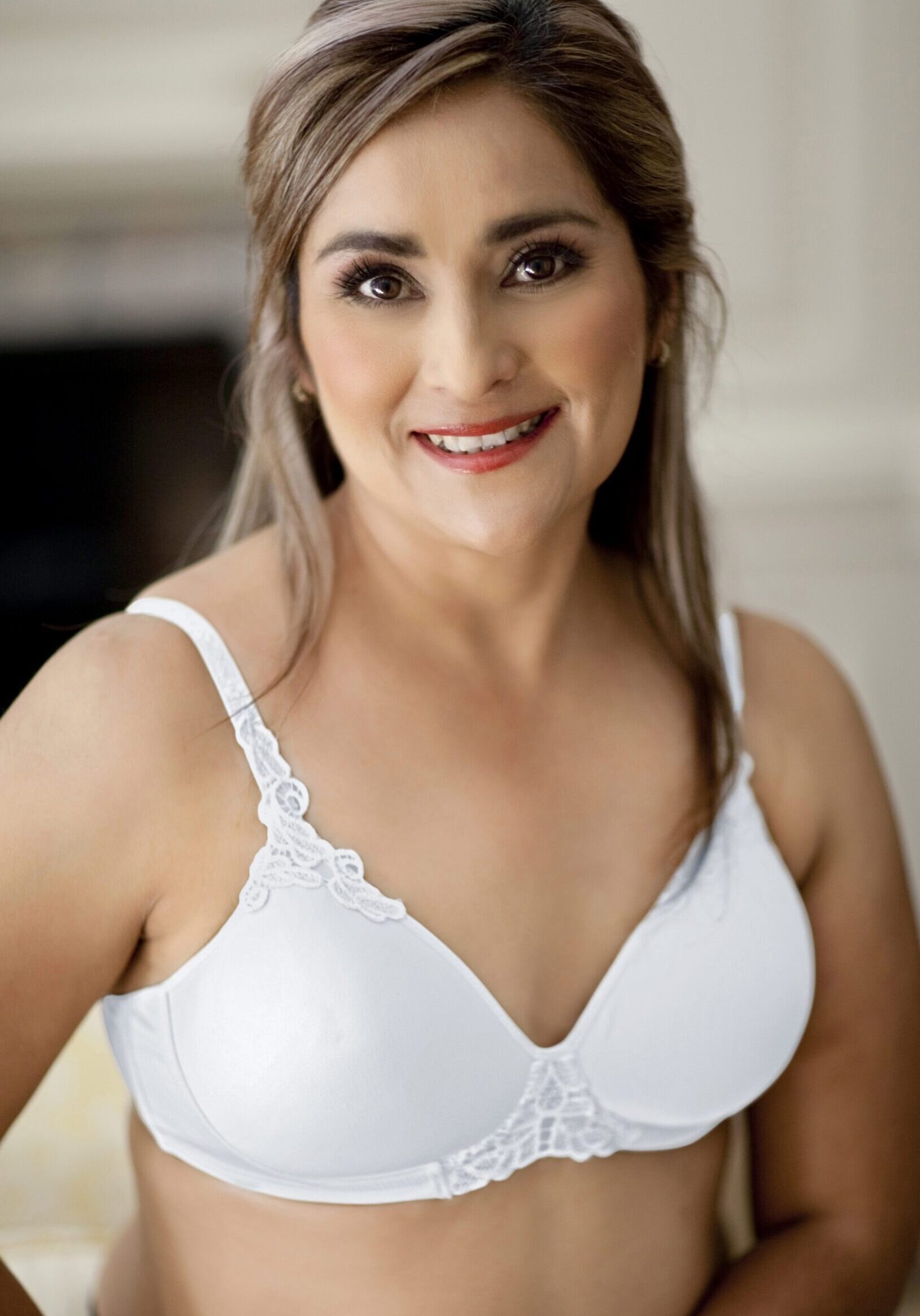 A woman in white bra smiling for the camera.