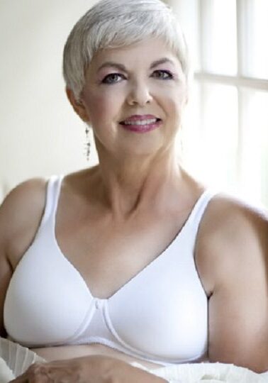 A woman in white bra smiling for the camera.