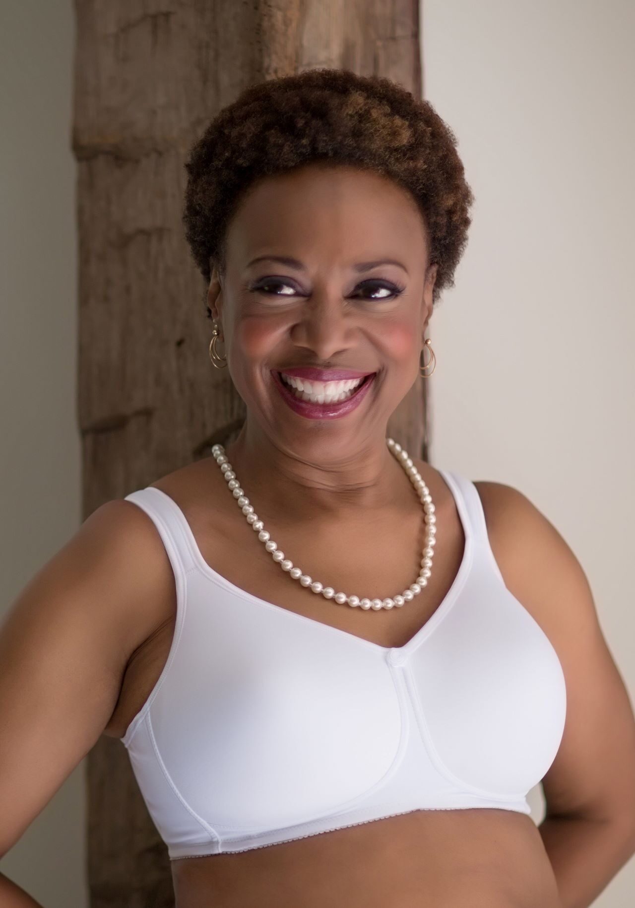 A woman in white top smiling for the camera.