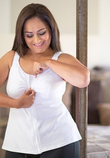 A woman in white shirt touching her breast.