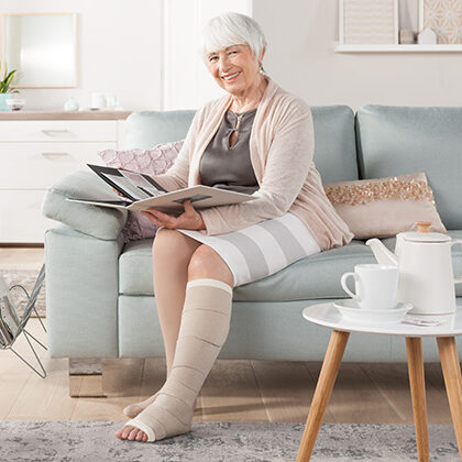 A woman sitting on the couch reading a magazine.