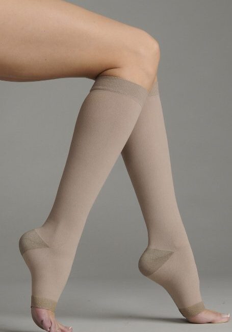 A woman walking in her beige knee high socks.