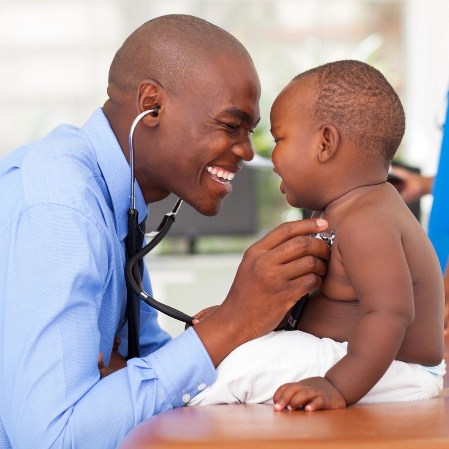 A man is playing with his baby boy